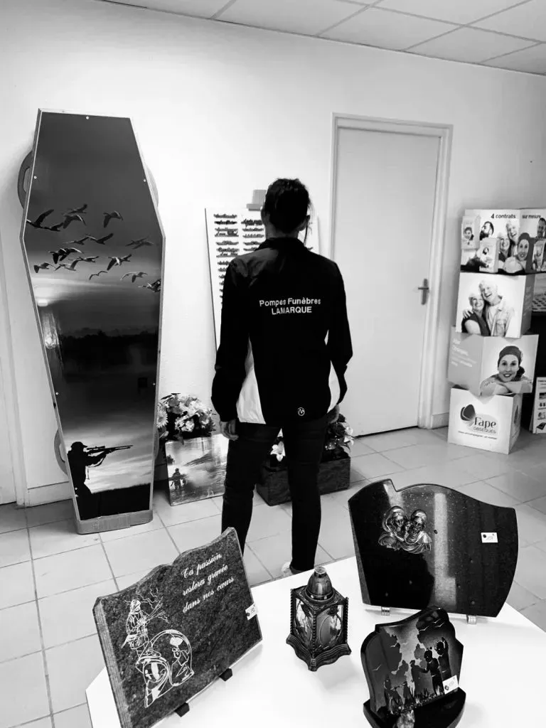 Vue arrière d'une personne portant une veste Pompes Funèbres Lamarque dans un showroom