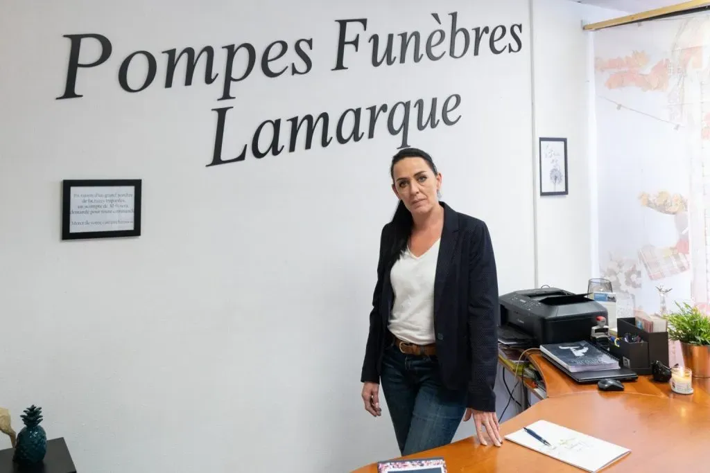 Conseillère funéraire en tenue professionnelle debout dans le bureau d'accueil