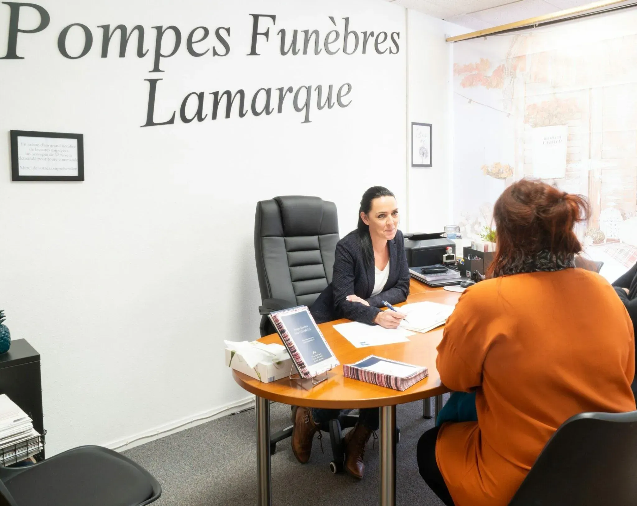 Conseillère funéraire recevant une cliente en rendez-vous dans son bureau